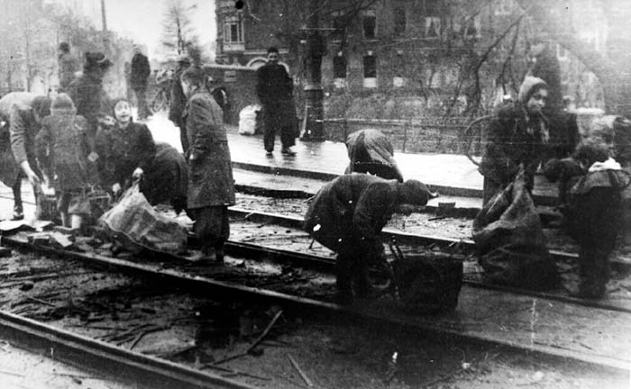 Onbekende fotograaf/Anefo, Mensen rapenhoutblokjes tussen tramrails (ca. 1944). Bron: Nationaal Archief (public domain)